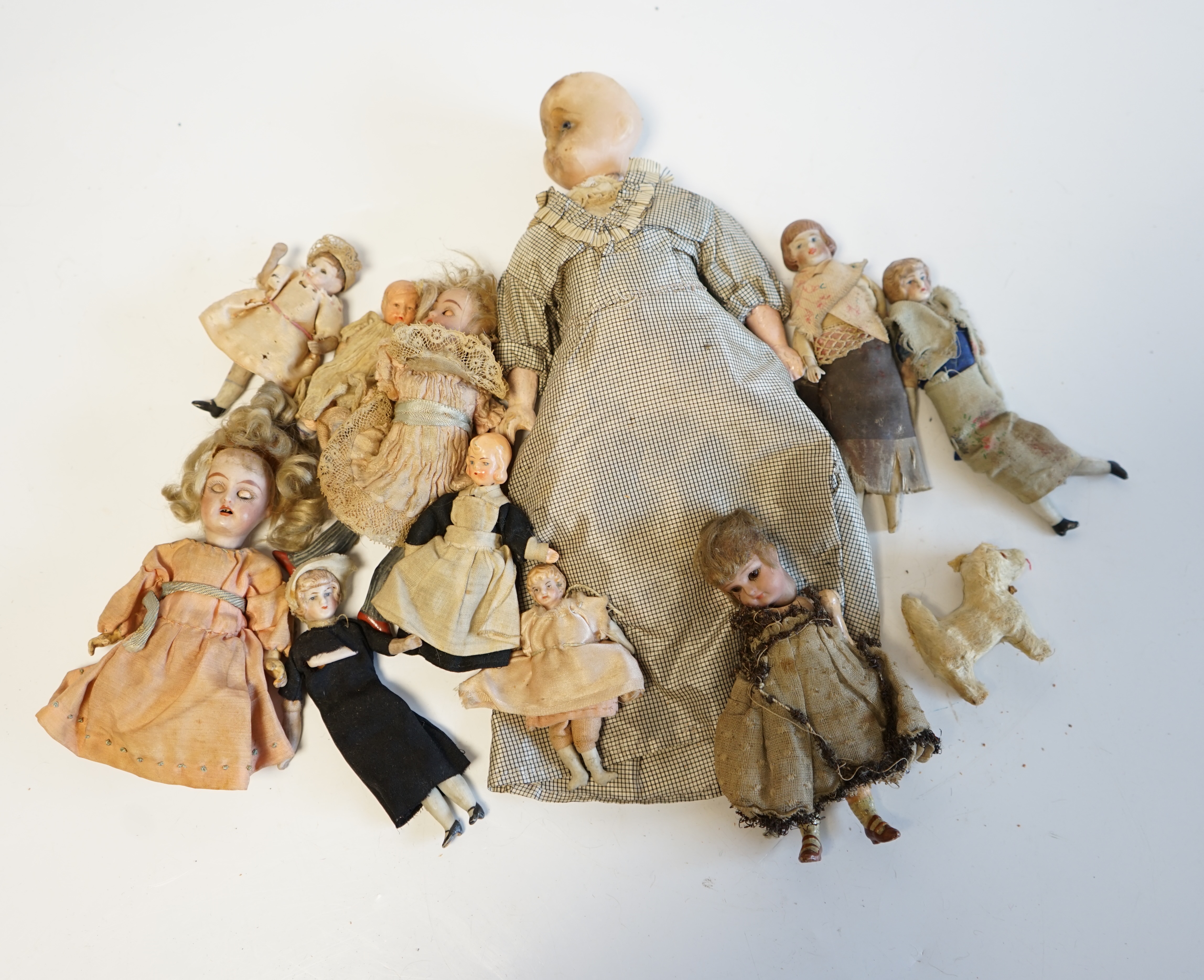 Eleven doll's house dolls, 19th and early 20th century, including two Kammer & Reinhardt bisque jointed dolls and a wax over composition doll in original clothes (12). Condition - fair